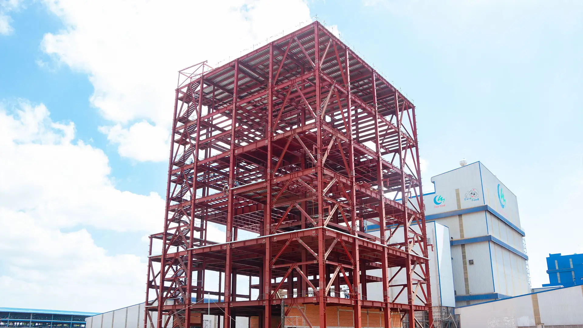 Multi-storey steel frame next to an operating plant
